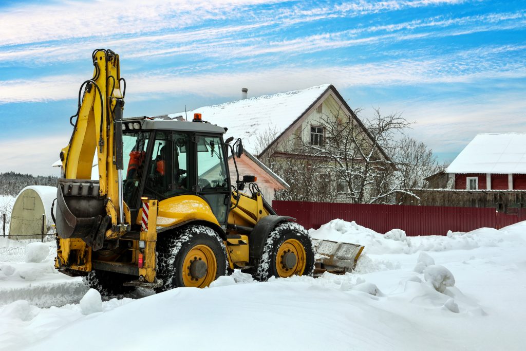Backhoe Loader Plowing Snow